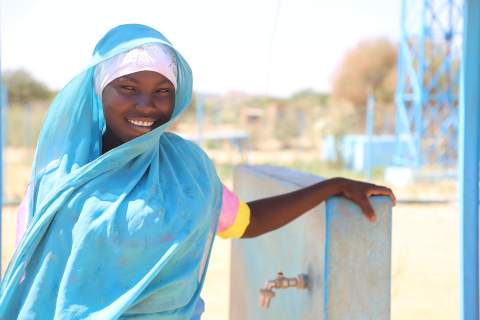 A young mother at the water point of the local health centre, Chad